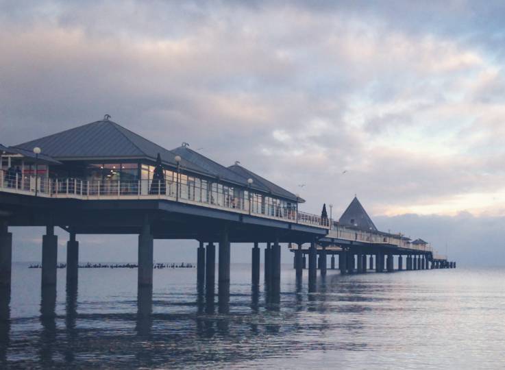 Seebrücke Heringsdorf auf Usedom bei ruhiger See und bewölktem Abendhimmel