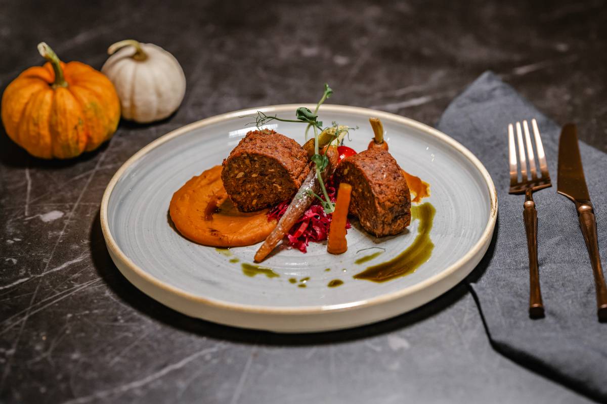 Veganer Bohnen-Nussbraten mit cremigem Kürbispüree, Wurzelgemüse und Rotkohl – modern angerichtet im Restaurant DÜNE 48 im DAS AHLBECK HOTEL & SPA
