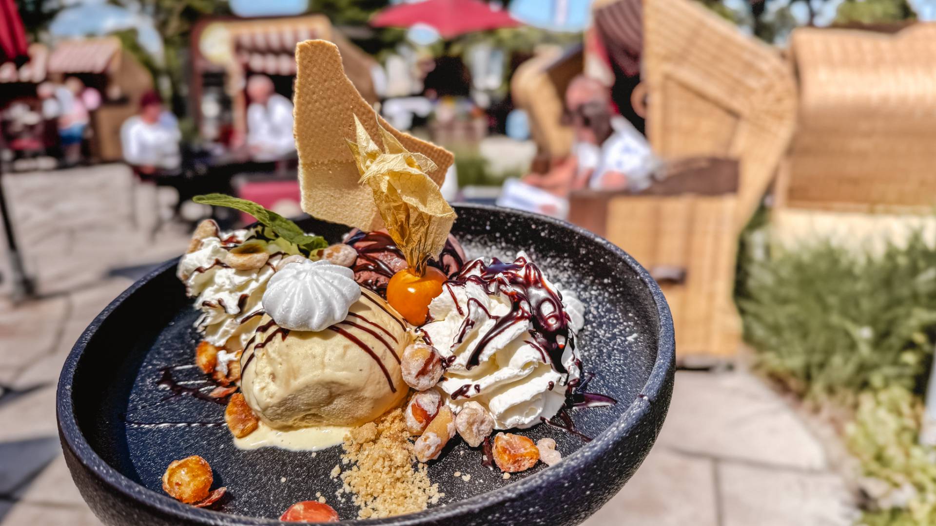 Eisteller Schoko-Nuss Terrasse Düne 48 DAS AHLBECK HOTEL & SPA mit 1 Kugel Schokoladeneis, 1 Kugel Macadamiaeis, kandierte Nüsse, Sahne, Schokoladensauce