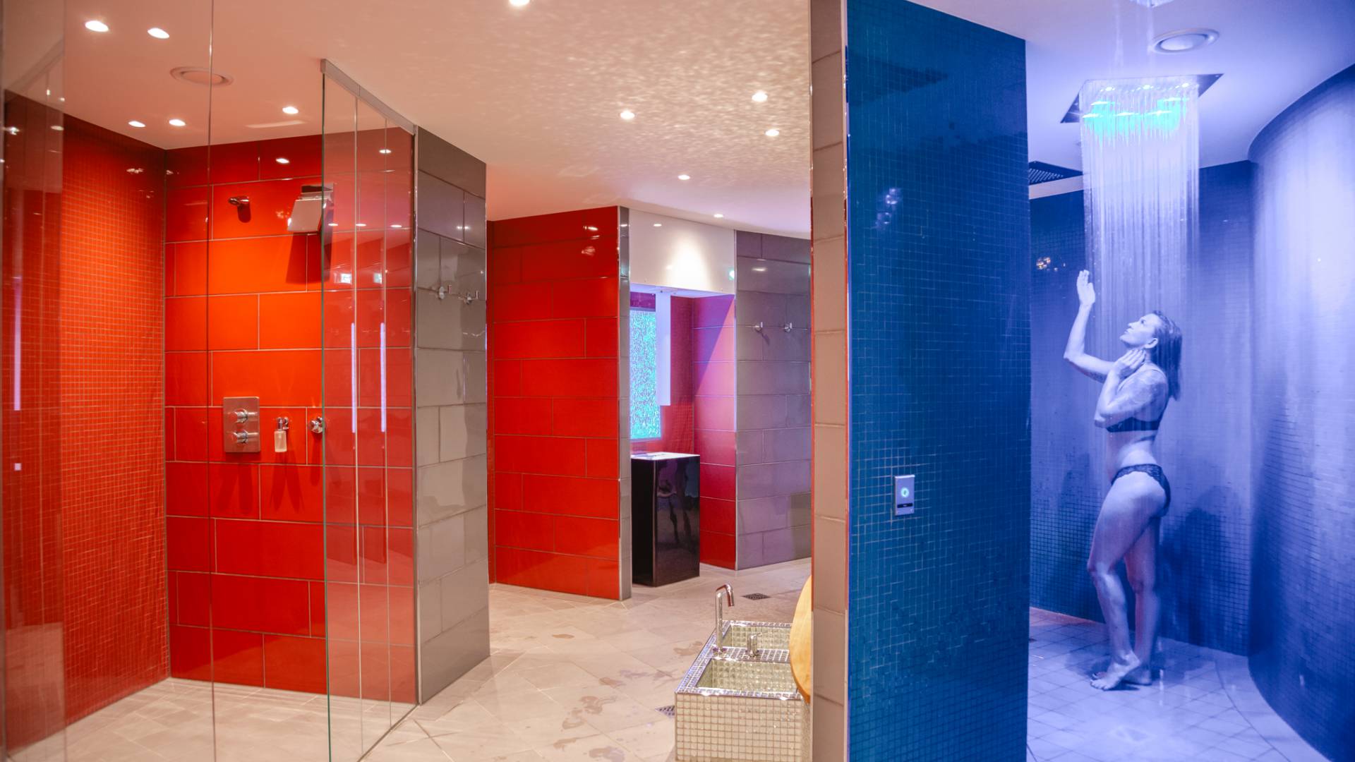Gäste erleben den stimmungsvoll beleuchteten Shower Walk im Spa de luxe des Das Ahlbeck Hotel & Spa****S