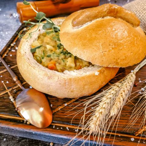 Rustikal servierter Eintopf im ausgehöhlten Brotlaib mit Deckel, dekoriert mit Getreideähren im Günter’s im DAS AHLBECK HOTEL & SPA