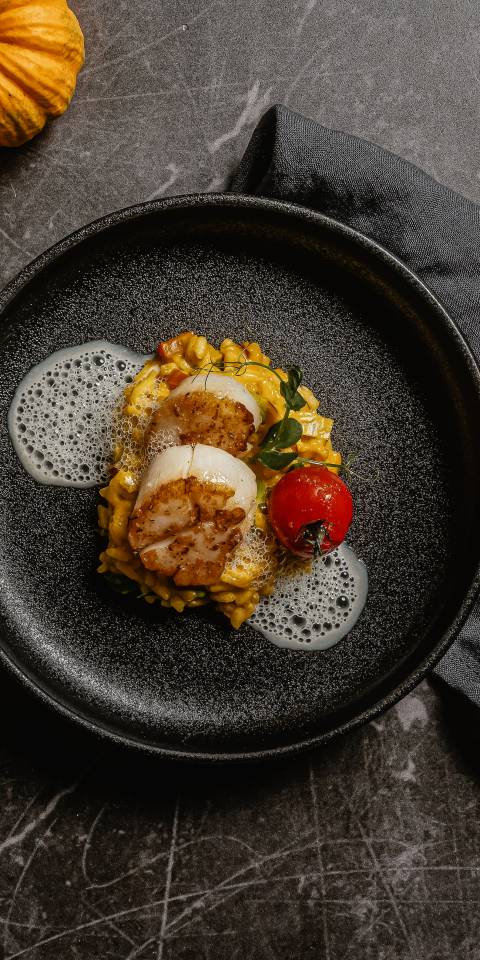 Gebratene Jakobsmuscheln auf cremigem Risotto mit Tomate und Schaum im Restaurant Düne 48 im DAS AHLBECK HOTEL & SPA auf Usedom