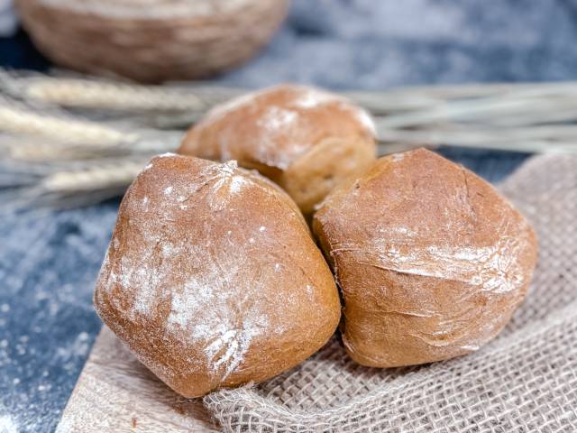 Frisch gebackene Roggenbrötchen vom DER AHLBECKER, rustikal bemehlt und auf Leinentuch angerichtet