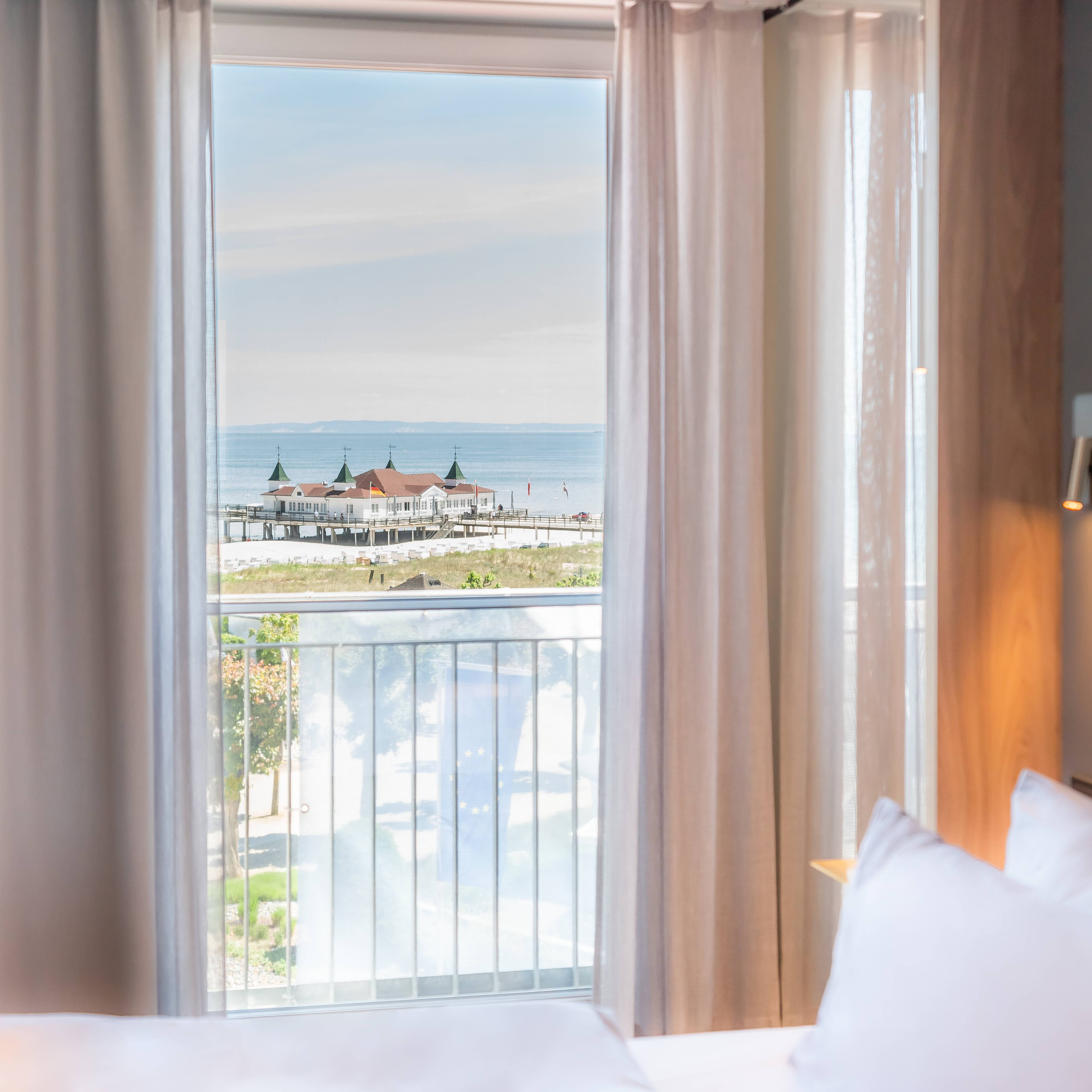 Blick aus einem Hotelzimmer des Das Ahlbeck Hotel & Spa auf die Promenade, den Ostseestrand und die Seebrücke Ahlbeck