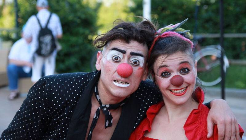 Zwei als Clowns geschminkte Straßenkünstler mit roten Nasen posieren lachend beim Internationalen Kleinkunstfestival auf der Ostseeinsel Usedom