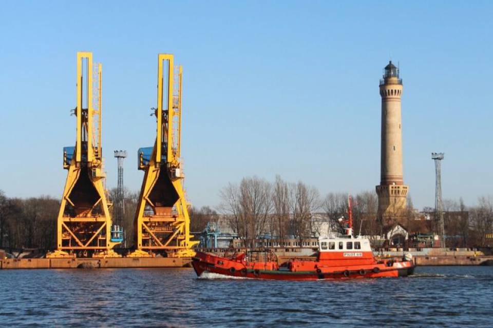 Der Leuchtturm von Swinemünde, ein imposantes Wahrzeichen an der Küste von Usedom, ragt hoch über den Hafen und ist ein wichtiger Orientierungspunkt für Schiffe auf der Ostsee. Umgeben von Kranausrüstungen und einem historischen Industriegebiet, bietet er einen malerischen Blick auf das maritime Umfeld