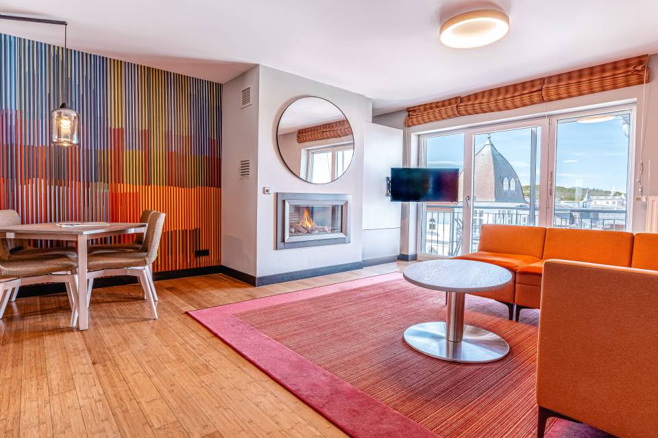 Modern eingerichtetes Zimmer mit Kamin, Sitzecke und Balkonblick im Das Ahlbeck Hotel & Spa****s