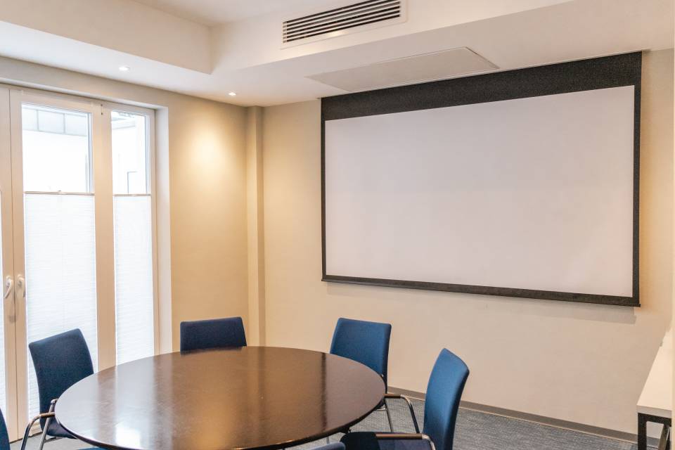 Tagungsraum Badehaus mit rundem Konferenztisch und Leinwand im Das Ahlbeck Hotel & Spa****s auf Usedom