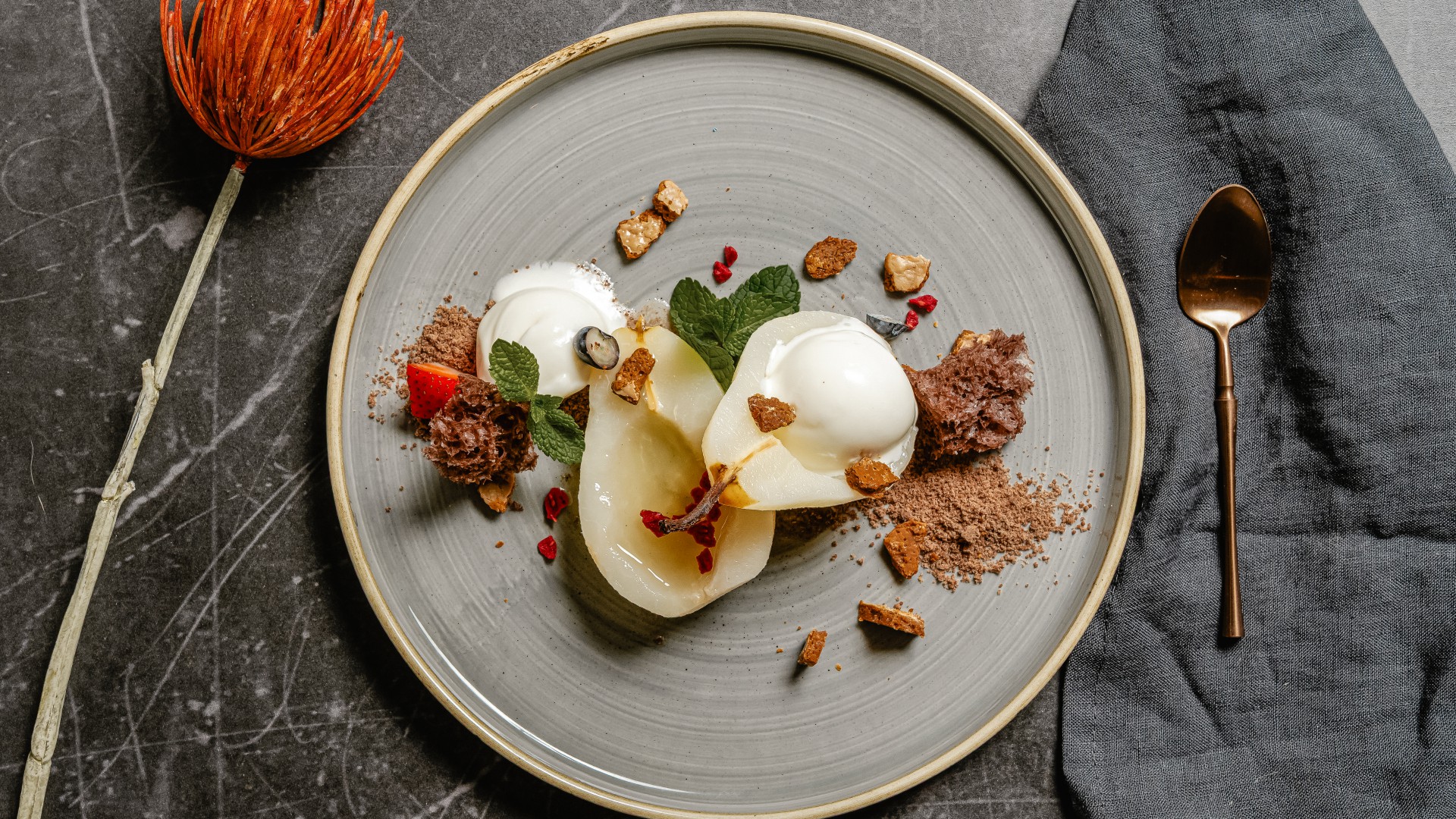 Pochierte Birne nach Art Birne Helene mit Vanilleeis, Schokolade und knusprigen Streuseln auf modern angerichtetem Teller im Restaurant Düne 48