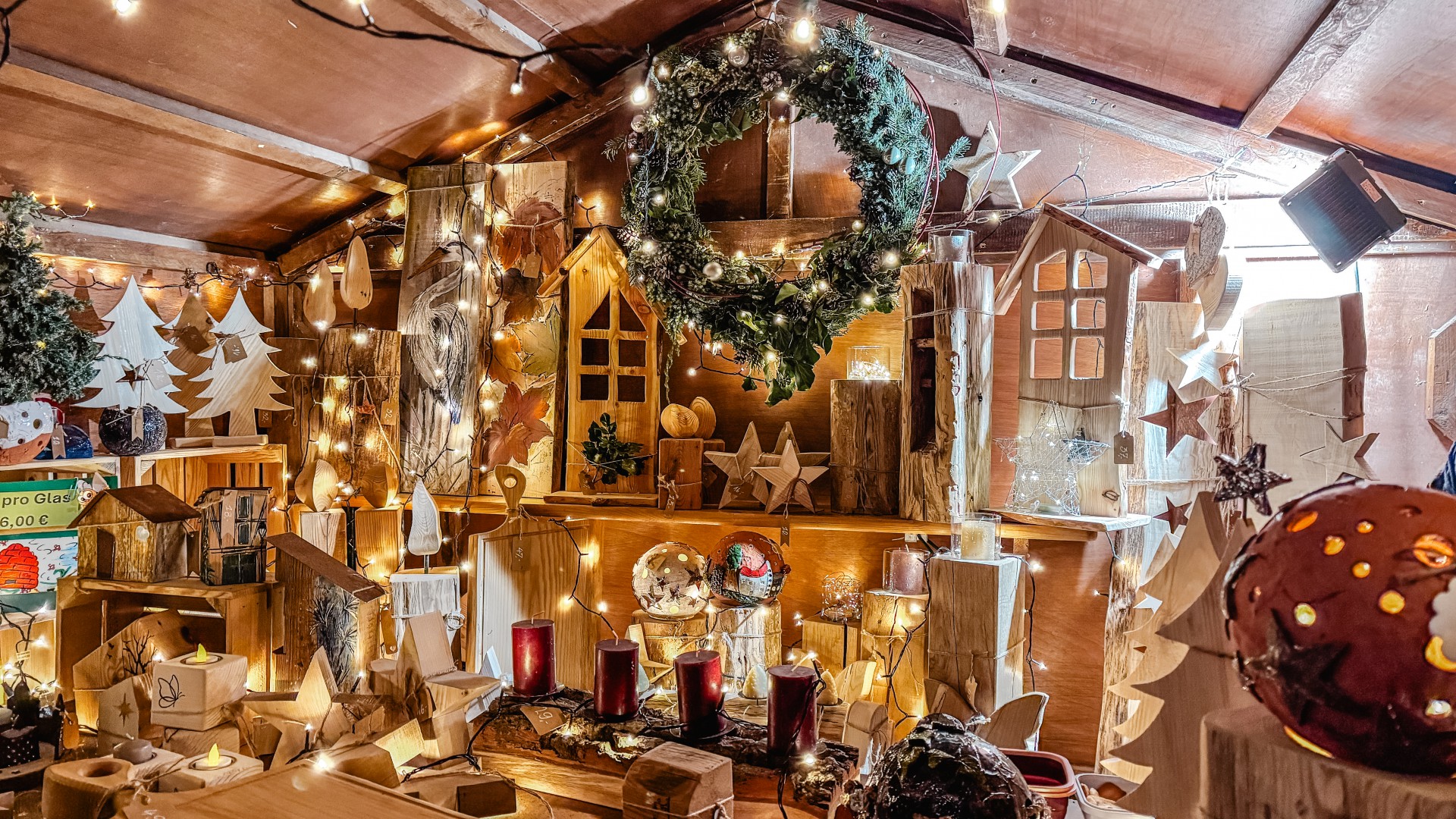 Dekorierte Holzbude zum Nikolausmarkt mit Lichterketten, Holzdeko z.B. aus Tannenbäumen, Sternen, Kerzenständern