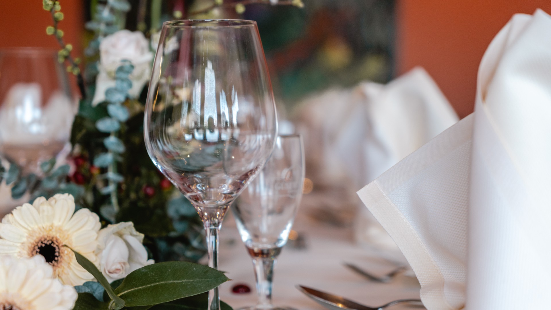 Festlich gedeckter Tisch mit Blumen, Gläsern und weißen Stoffservietten im Das Ahlbeck Hotel & Spa****s in Ahlbeck auf Usedom – stilvoll tagen und feiern.