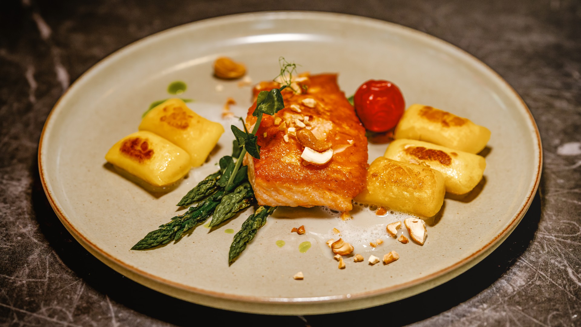 Filet vom Lachs mit grünem Spargel, gerösteten Cashewnüssen, Gnocchi im Restaurant DÜNE 48