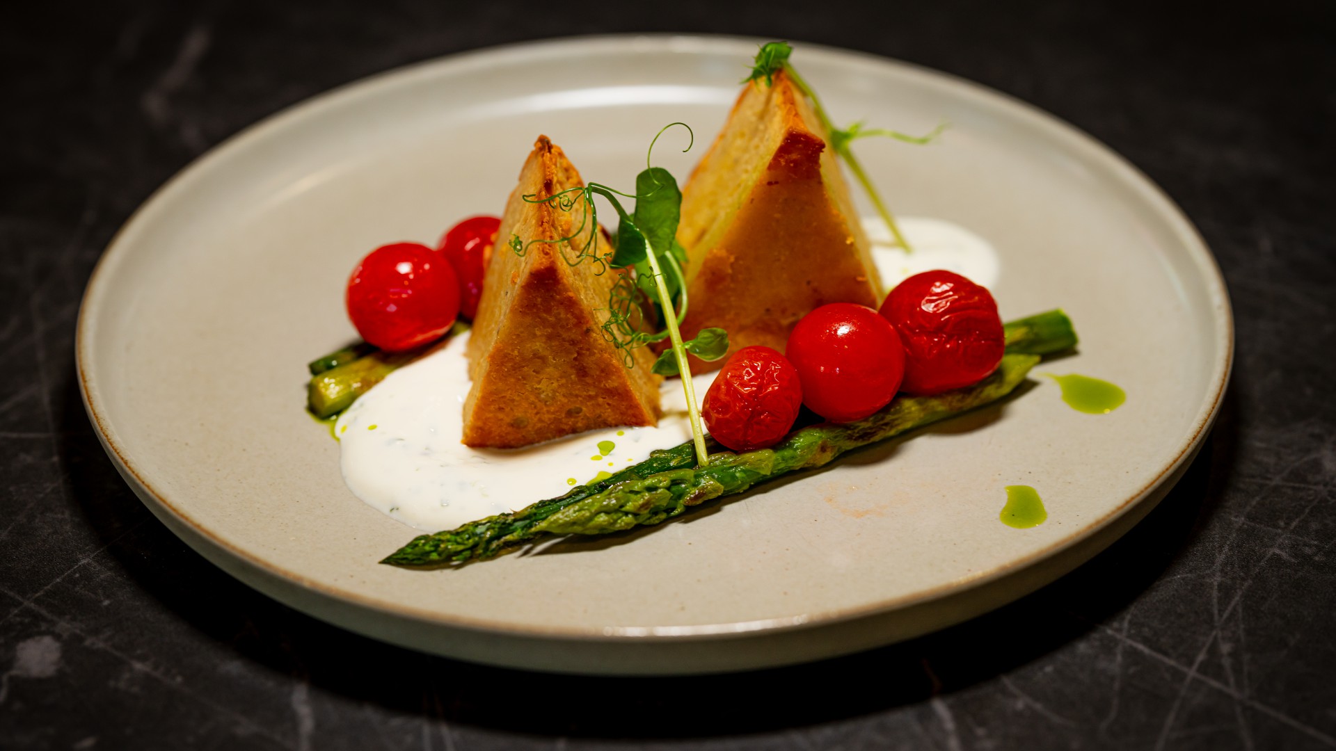 Kartoffel-Gorgonzola-Törtchen mit Joghurtsauce, grüner Spargel, geschmolzene Tomaten im Restaurant DÜNE 48